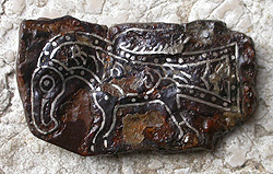 Fibula con raffigurato animale alato fantastico in ferro con decorazione in agemina di filo d’argento, tomba longobarda di Castelli Calepio, VI sec. d.C.